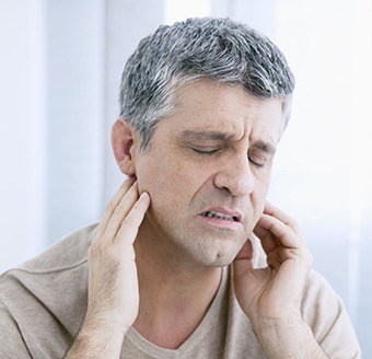 Man holding jaw in pain