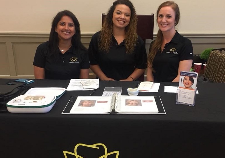 Three team members at community event table