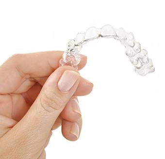 Hand holding an Invisalign tray