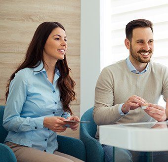 Man and woman smiling during dental consultation