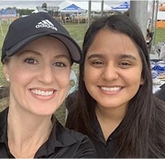 Two smiling dental team members at event